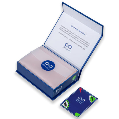 SILKAVA silk pillowcase in packaging with tissue paper, alongside Origin Series collectible card, pink